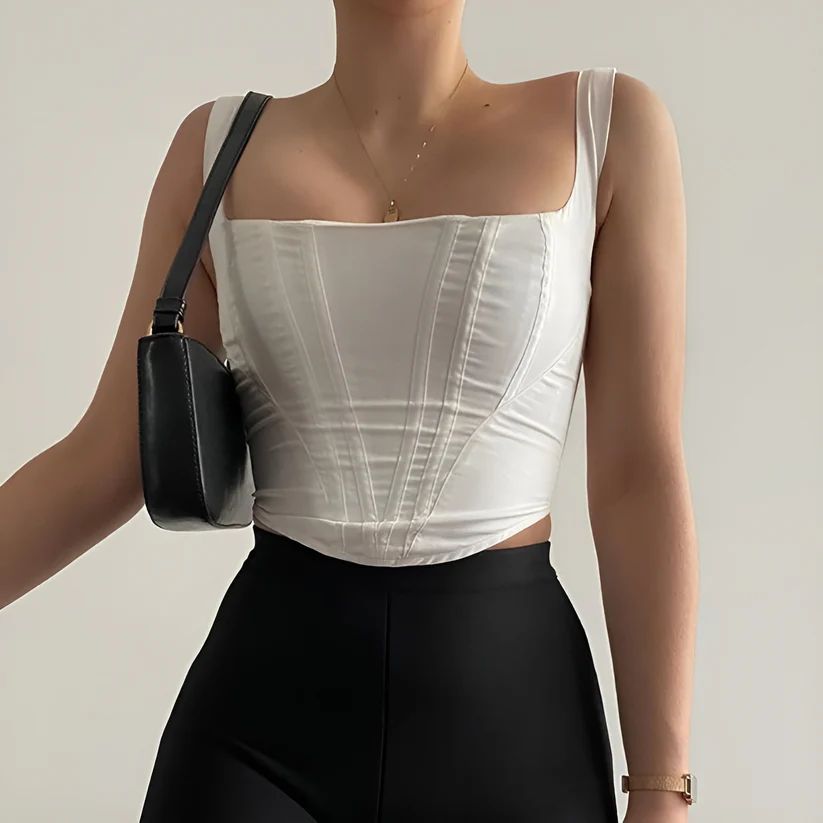 a woman wearing a white top and black pants
