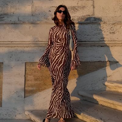 a woman in a zebra print dress is standing on some steps