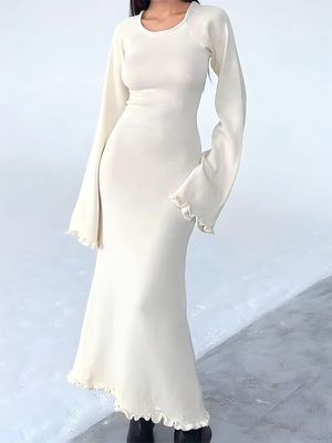 a woman in a white dress posing for a picture