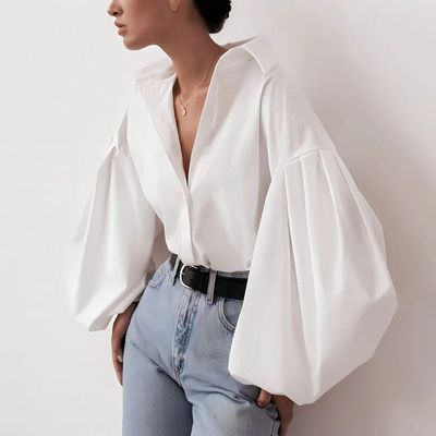 a woman wearing a white blouse and jeans