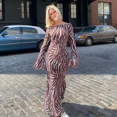 a woman in a zebra print dress standing in front of a building