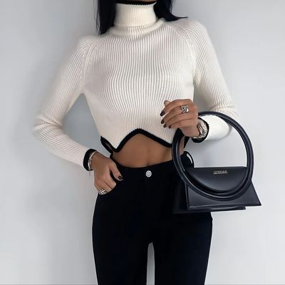 a woman in a white top holding a black purse