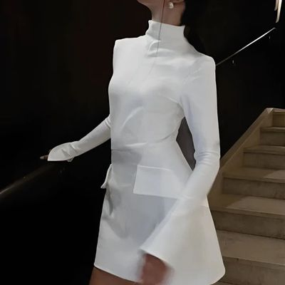 a woman in a white dress is holding an umbrella