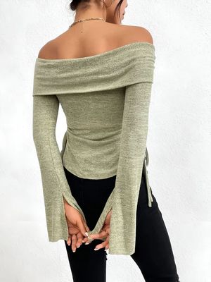 a woman wearing a green off the shoulder top