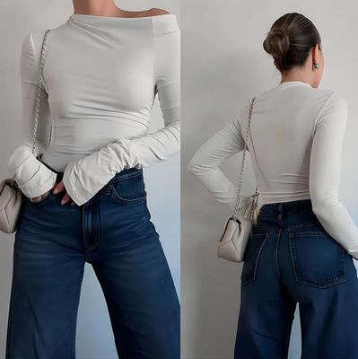 a woman wearing a white top and jeans