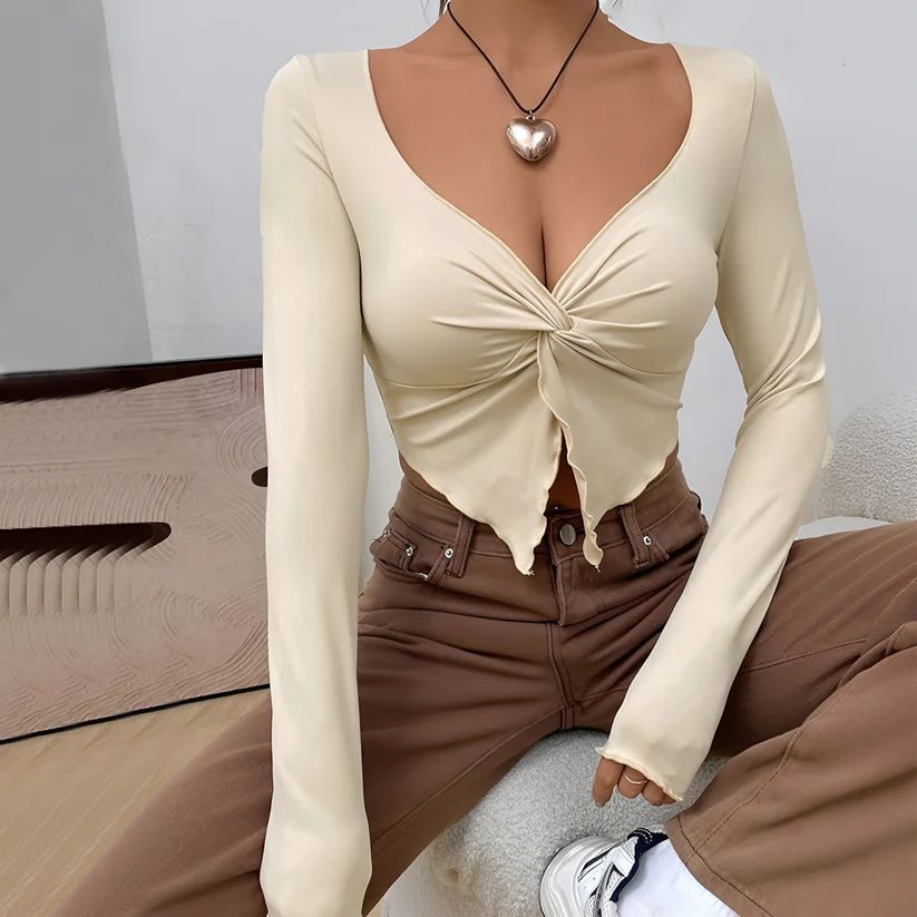 a woman wearing a tan top and brown pants
