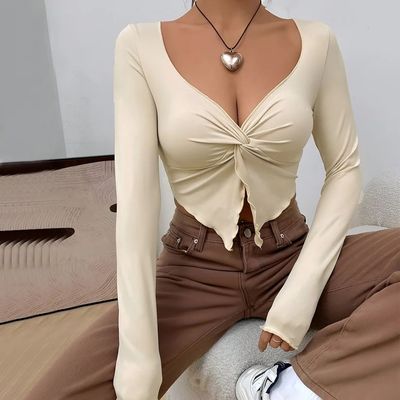 a woman wearing a tan top and brown pants