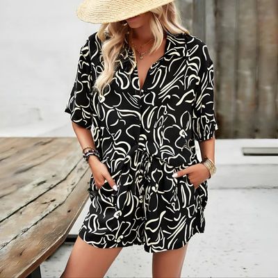a woman wearing a black and white dress and a straw hat