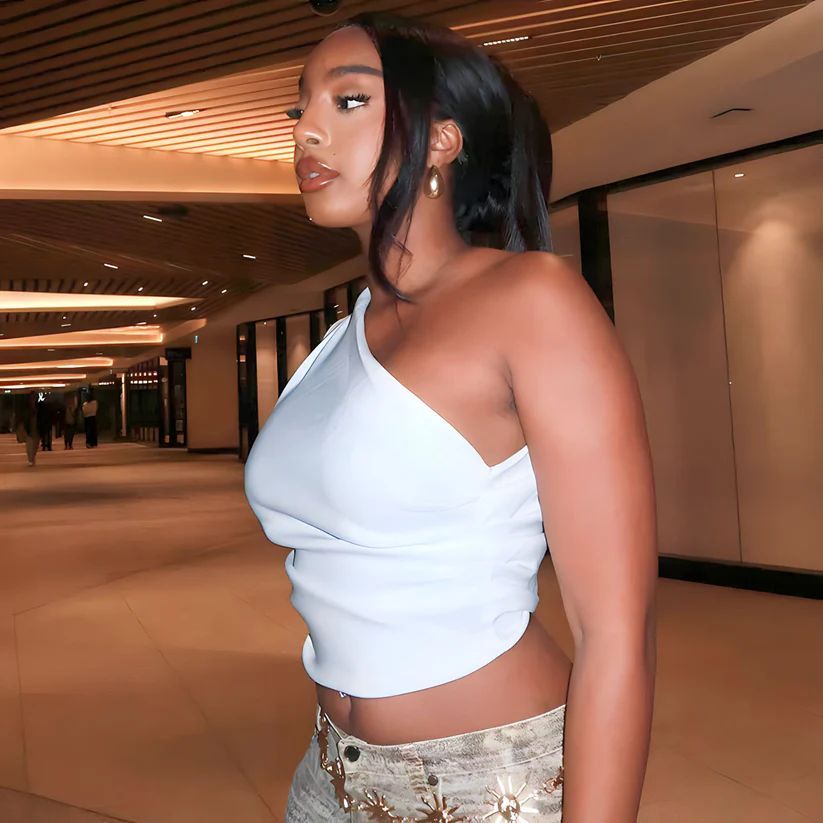 a woman in a white top and gold skirt