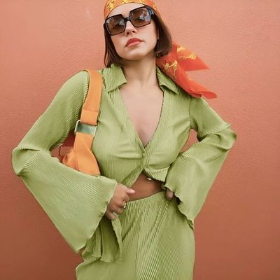 a woman in a green outfit with a bird on her head