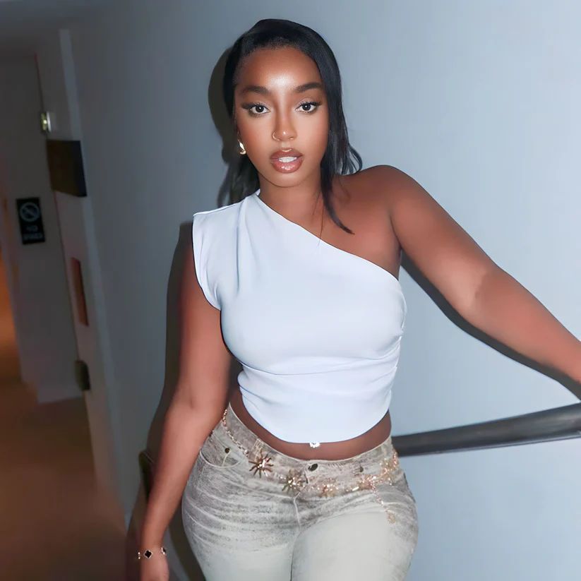 a black woman in a white top and jeans