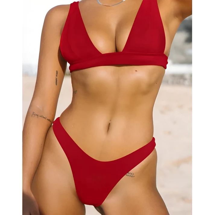 a woman in a red bikini top on the beach