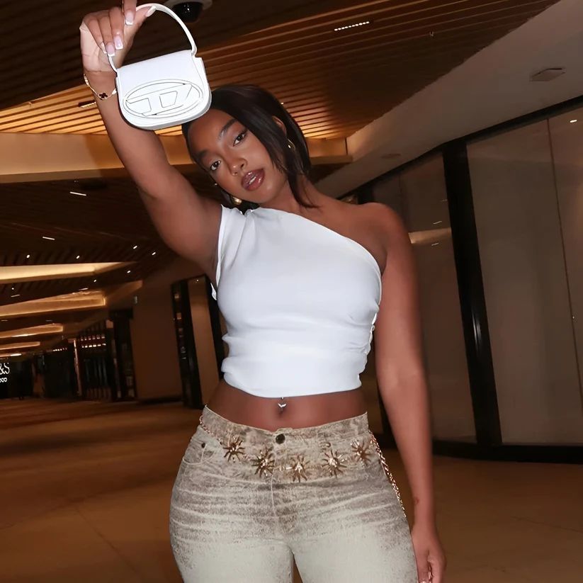 a woman in a white top holding a white purse