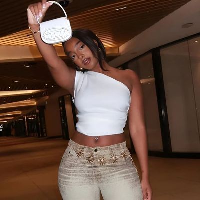 a woman in a white top holding a white purse