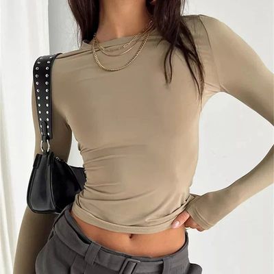 a woman wearing a tan top and grey pants