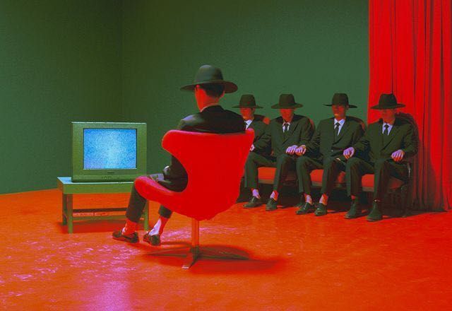 a group of men sitting in front of a tv