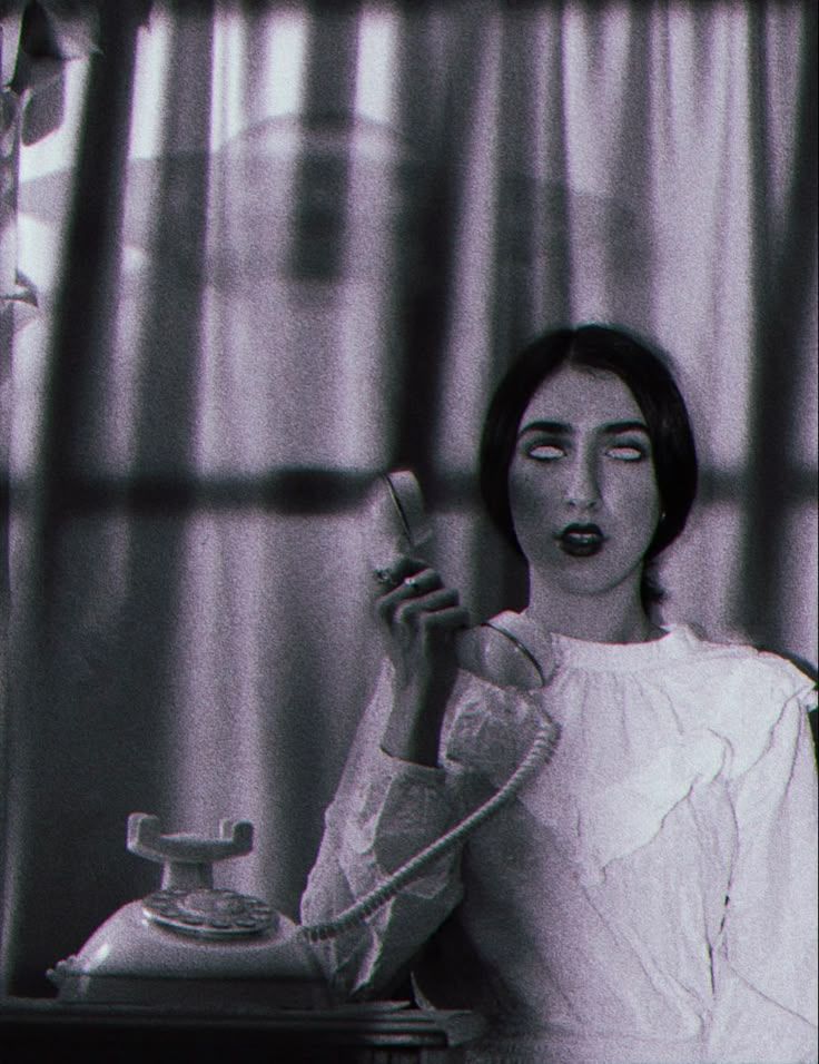 a black and white photo of a woman holding a phone
