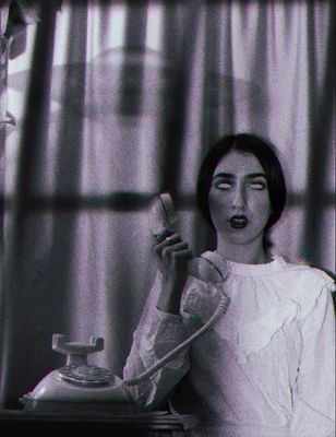 a black and white photo of a woman holding a phone