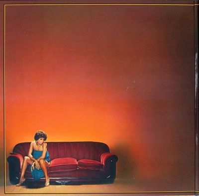 a woman sitting on top of a red couch