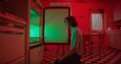 a man sitting on the floor in front of an oven