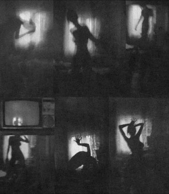 a black and white photo of a woman dancing in front of a tv