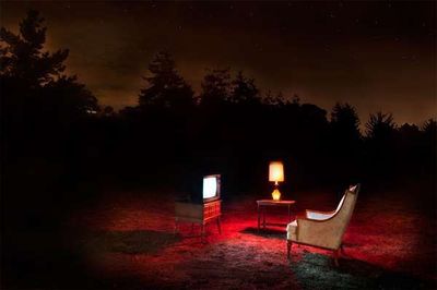 a couple of chairs sitting in the middle of a field
