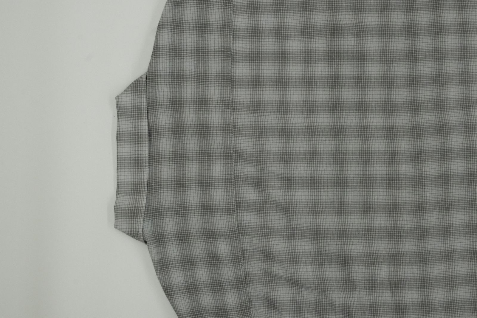 a black and white checkered shirt hanging on a wall