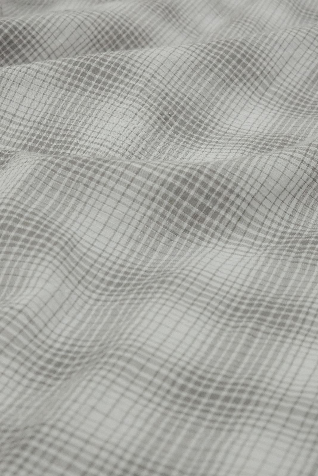 a close up of a bed with a checkered comforter