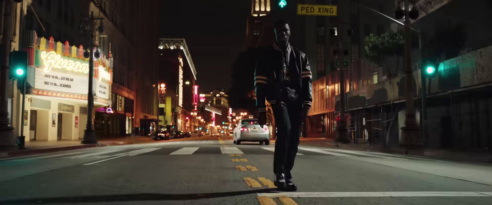 a man walking across a street at night