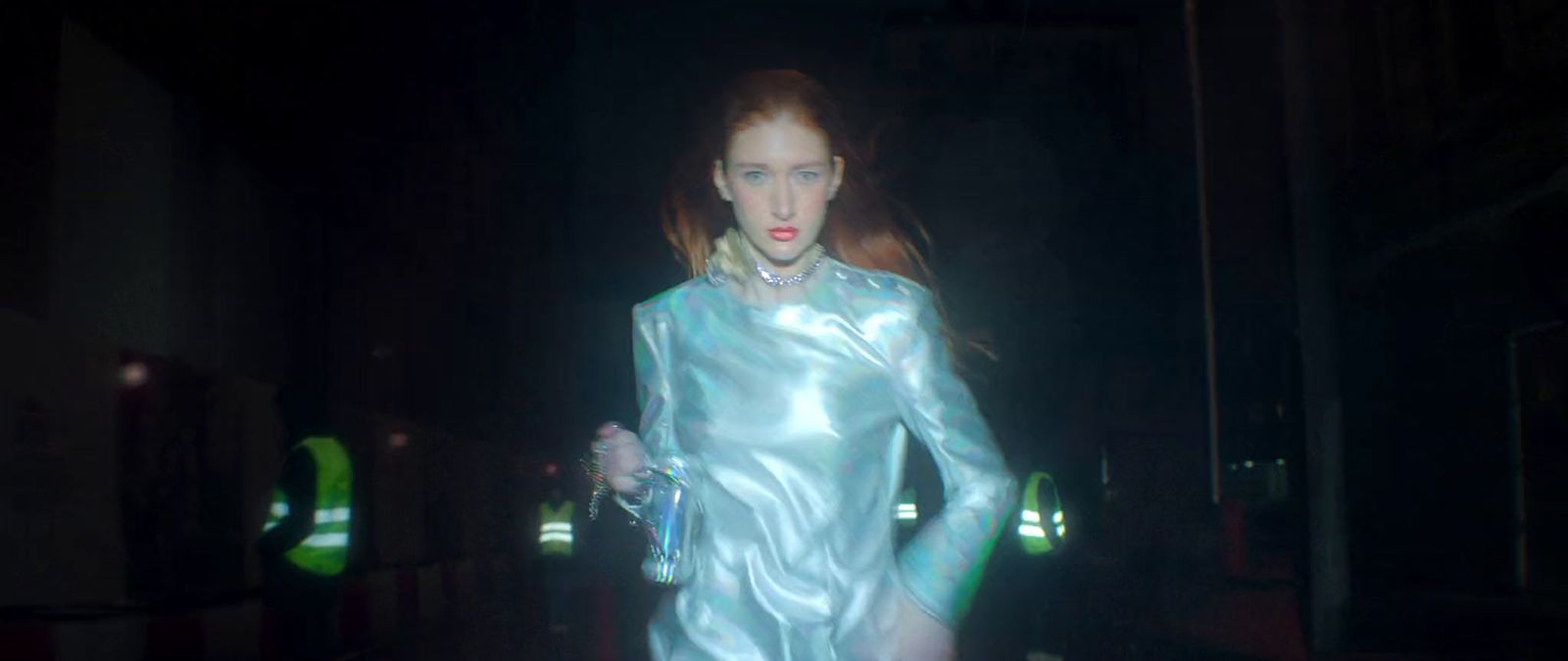 a woman walking down a dark street at night