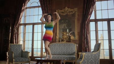 a woman in a rainbow dress standing in a living room