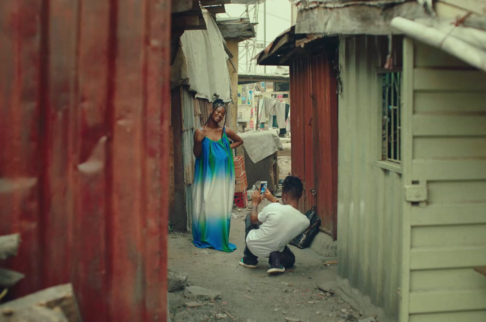 a man kneeling down next to a woman in a blue dress