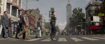 a group of people walking across a street