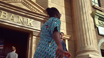 a woman in a dress standing outside of a bank