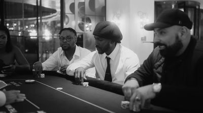 a group of people sitting around a table playing cards