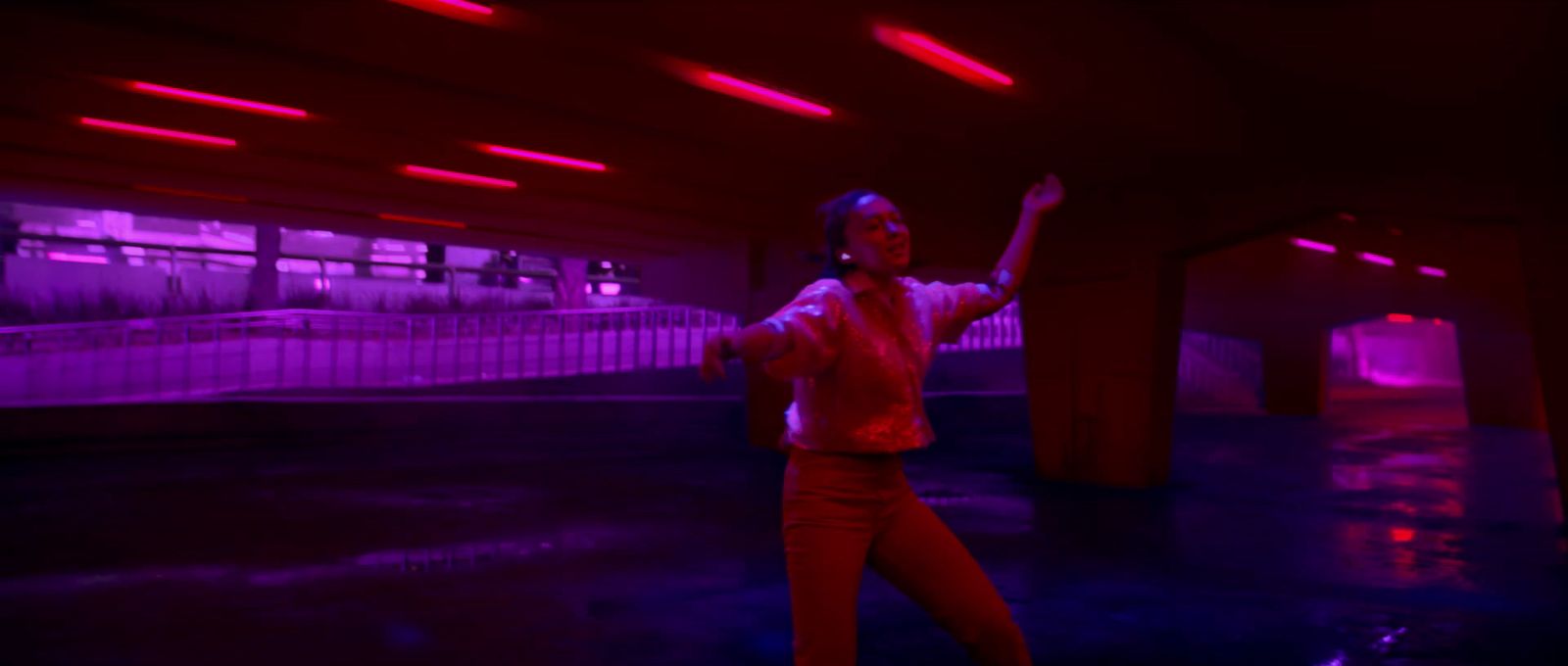 a woman standing in a room with red lights