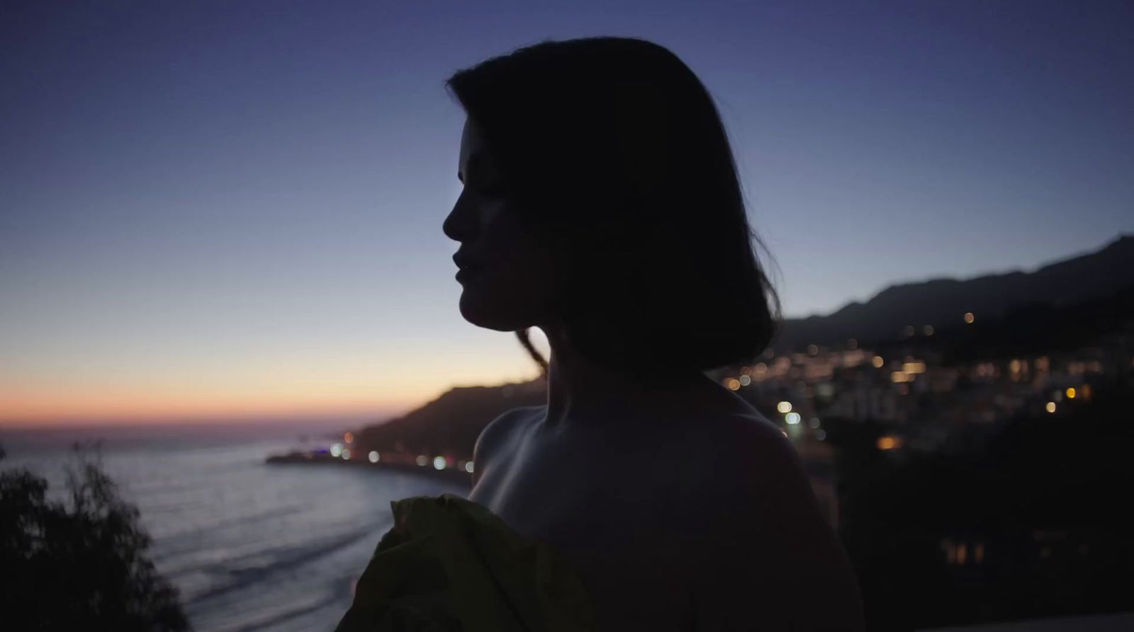 a woman standing in front of a body of water