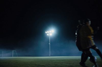 a couple of people standing on top of a soccer field