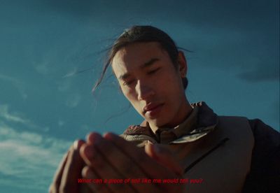 a woman holding her hands together with a sky in the background