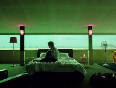 a person sitting on a bed in a room