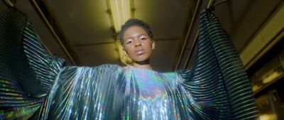 a woman in a shiny dress standing in a room