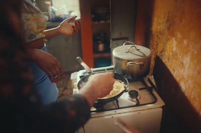 two people cooking food on a stove top