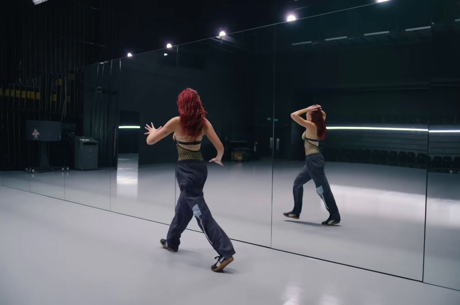 a woman is dancing in front of a mirror