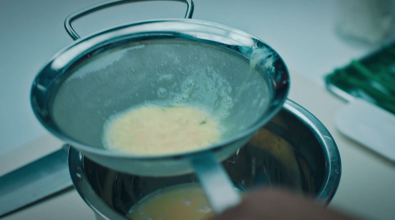 a person stirring a sauce in a pot on a stove