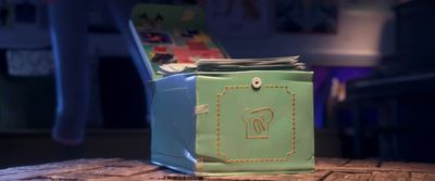 a green and blue bag sitting on top of a wooden table