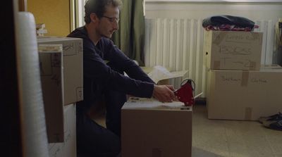 a man sitting on top of a cardboard box