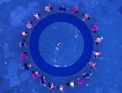 a group of people standing around a blue circle