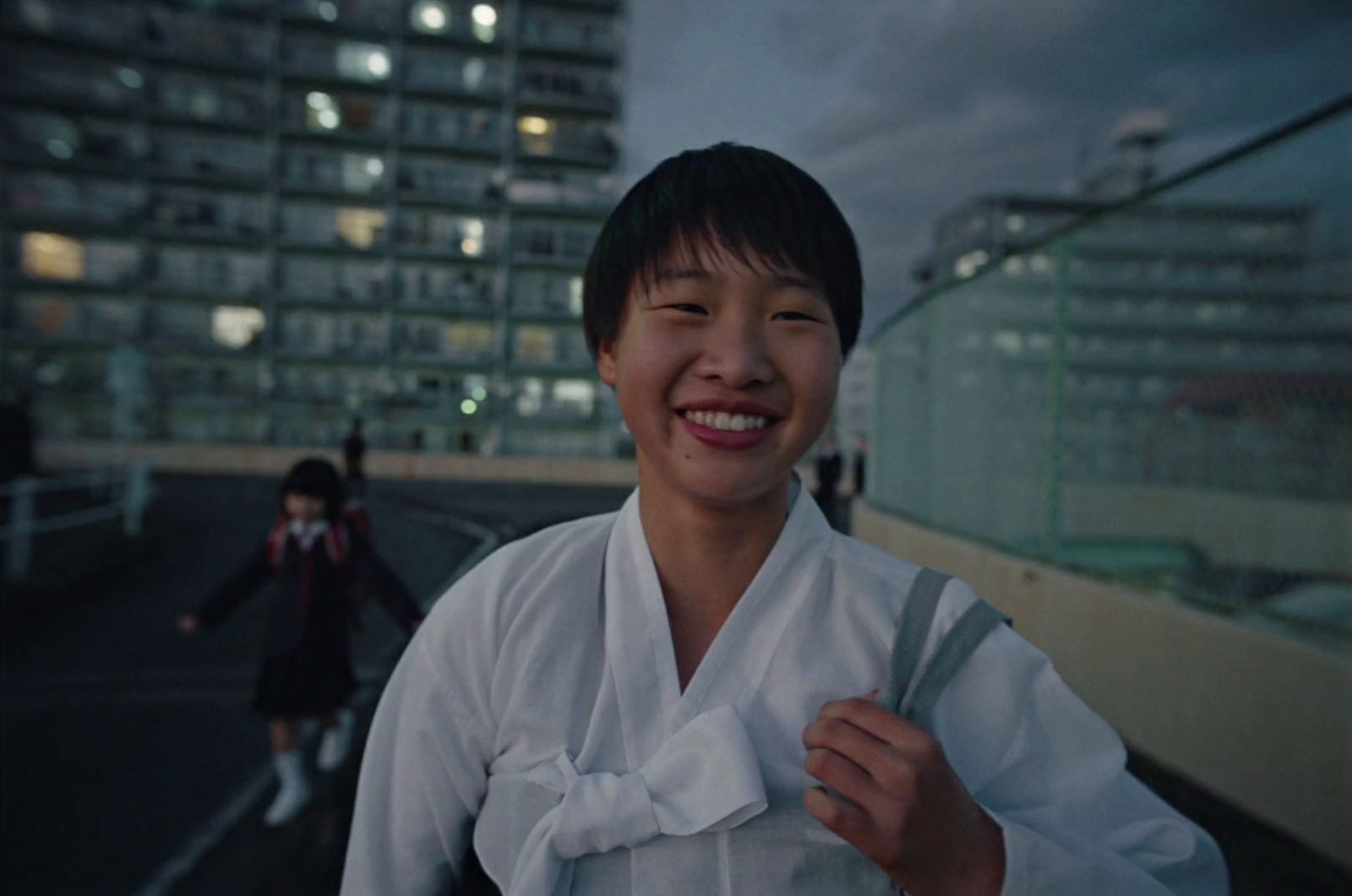 a woman in a white shirt is smiling