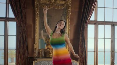 a woman in a rainbow dress standing in a room