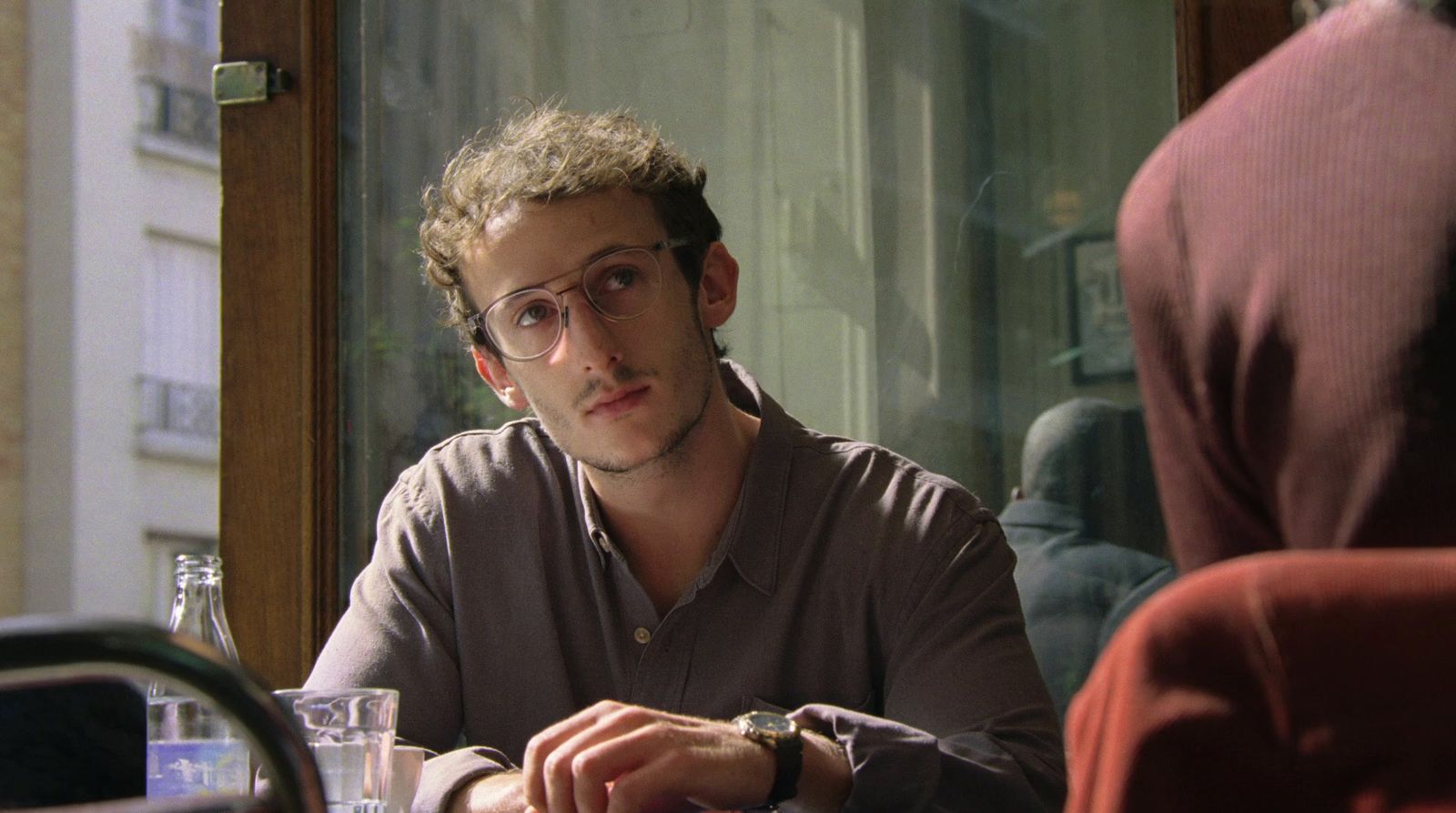 a man sitting at a table in front of a window